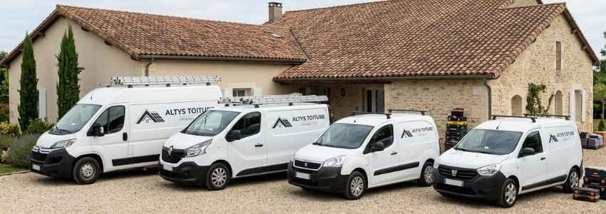 Les fourgons logotés Altys Toiture Le Taillan-Médoc alignés devant une maison médocaine en tuile